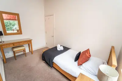 a bedroom with a bed and a desk and a mirror at Crandy Nook in Keswick