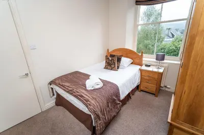 a small bedroom with a bed and a window at Crandy Nook in Keswick