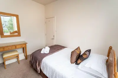 a bedroom with a bed and a desk and a window at Crandy Nook in Keswick