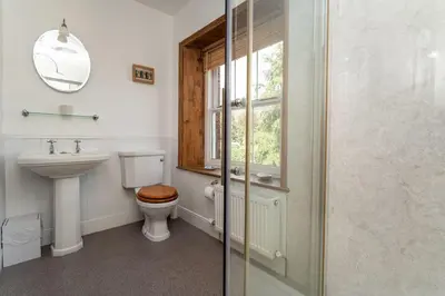 a bathroom with a toilet and a sink and a window at Coleridge Cottage in Keswick