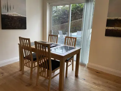 a dining room table with four chairs and a window at Rock Lynn in Braithwaite