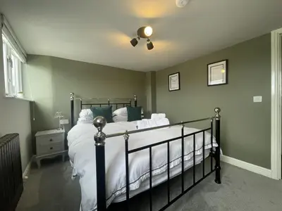 a bedroom with a bed with white sheets and a fan at Mountain View in Keswick