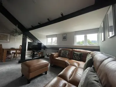 a living room with a leather couch and a tv at Mountain View in Keswick