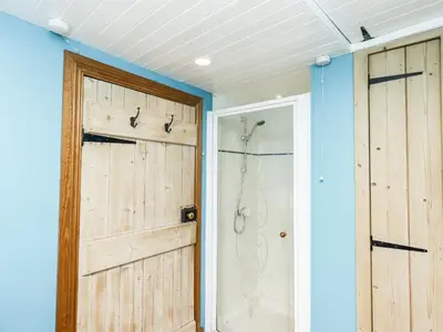 a bathroom with a shower and a sliding door at 2 Burnside Place in Kirkcudbright