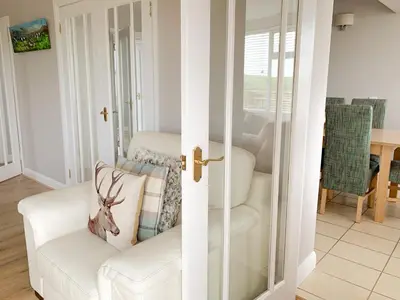 a living room with a white chair and a mirror at Float bay view in Stranraer