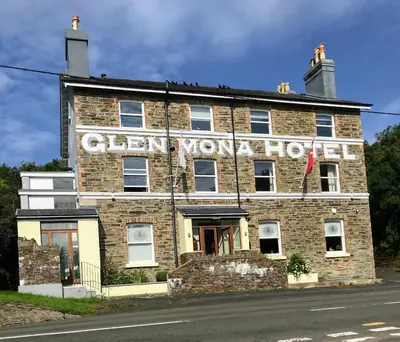 an old brick building with a sign on it at The Glen Mona Hotel in Maughold