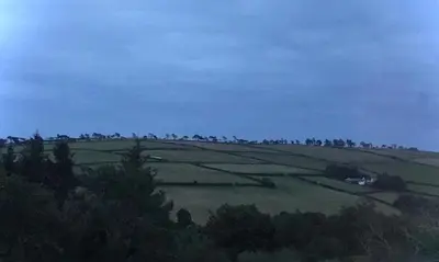 a green field with trees on top of a hill at The Glen Mona Hotel in Maughold