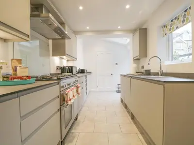 a large kitchen with white cabinets and a sink at Shields in Keswick