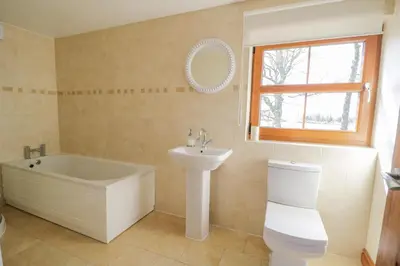 a bathroom with a tub and a sink and a toilet at Bramblewood Cottage in Crookdake