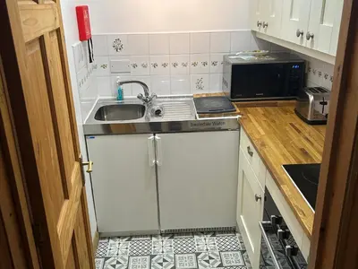 a small kitchen with a sink and a microwave at Swaledale Watch Garden Annexe in Wigton