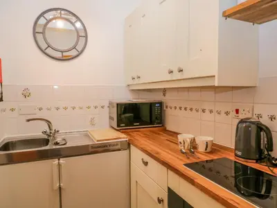 a kitchen with a sink and a microwave at Swaledale Watch Garden Annexe in Wigton