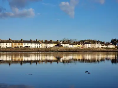 a large body of water with buildings in the background at Harbourside in Garlieston