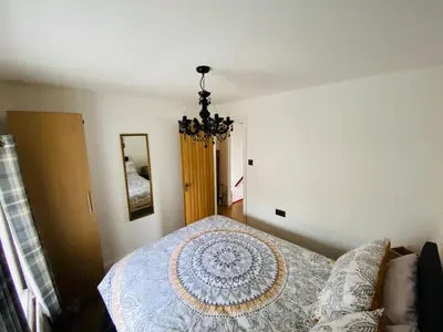 a bedroom with a bed and a chandelier at Parkside Mews in Frizington