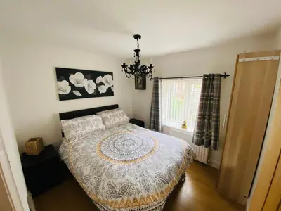 a bedroom with a bed and a chandelier at Parkside Mews in Frizington