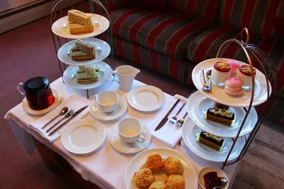 a table with plates of cakes and desserts on it at Woodlands Country House & Cottage in Ireby