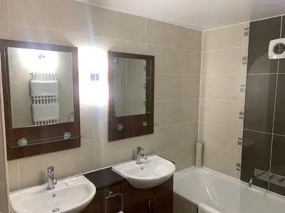 a bathroom with two sinks and a mirror and a tub at Ullswater Suite in Penrith