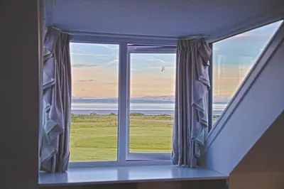 a window in a room with a view of the ocean at Arthur's Cottage in Dumfries