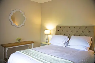a bedroom with a bed and a table with a lamp at Arthur's Cottage in Dumfries