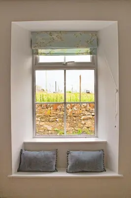 a window in a room with two pillows in front at Arthur's Cottage in Dumfries
