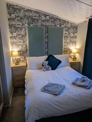 a teddy bear sitting on top of a bed at A and C Lodge Plot 21 2 double bedrooms PLOT 21 With HOT TUB 1 pet only No Commercial Vans 4pm check in in High Hesket