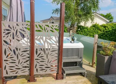 a privacy fence with a table on a patio at A and C Lodge Plot 21 2 double bedrooms PLOT 21 With HOT TUB 1 pet only No Commercial Vans 4pm check in in High Hesket