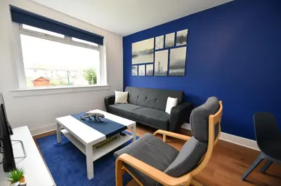 a living room with a couch and a table at Greensleeves Place in Troon