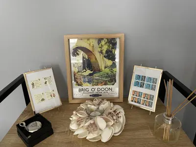 a table topped with pictures and a plate of shells at Rose Apartment 2-Bed Apt Sleeps 4 Town Centre Ayr in Ayr