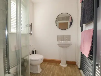 a bathroom with a toilet and a sink and a mirror at 26 Hycemoor Way in Millom