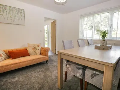 a living room with a table and a couch at 26 Hycemoor Way in Millom