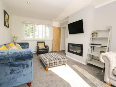a living room with a couch and a fireplace at 26 Hycemoor Way in Millom