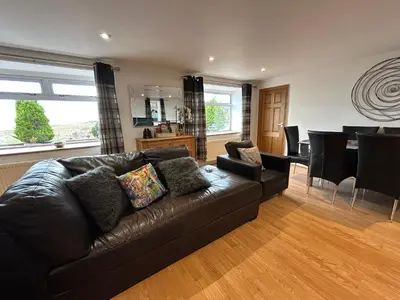 a living room with a couch and a dining room at Solway Firth View in Annan