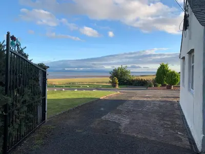 a gate to a house with a view of the ocean at Solway Firth View in Annan