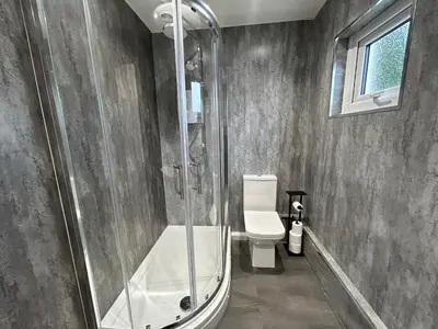 a bathroom with a shower and a toilet at Solway Cottage in Annan