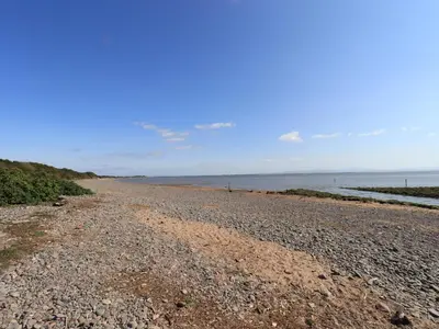 a rocky beach with the ocean in the background at Solway Cottage in Annan