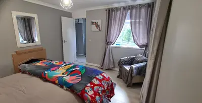 a bedroom with a bed and a chair and a window at Modernised 1720s cottage Newton Stewart Scotland in Newton Stewart