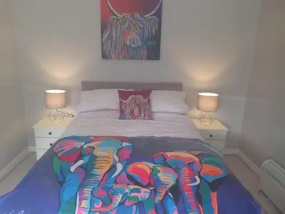 a bed with a bunch of elephants on it at Modernised 1720s cottage Newton Stewart Scotland in Newton Stewart