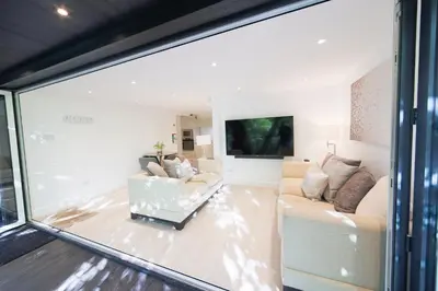 a living room with a couch and a tv at The Hide in Carlisle