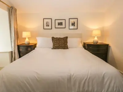 a bedroom with a large white bed with two lamps at Waterside in Ravenglass