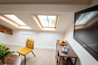 a living room with skylights and a table and a chair at Luxury Studio Apartment - Town Centre in Whitehaven