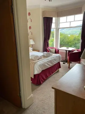 a hotel room with a bed and a large window at Ouse Bridge House in Bassenthwaite Lake
