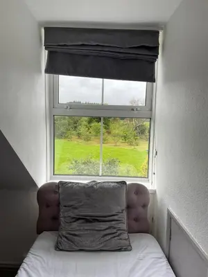a pillow sitting on a bed in front of a window at Ouse Bridge House in Bassenthwaite Lake