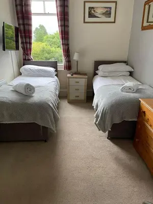 a bedroom with two twin beds and a window at Ouse Bridge House in Bassenthwaite Lake