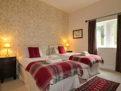 a bedroom with two beds and a window at Cloud End in Keswick