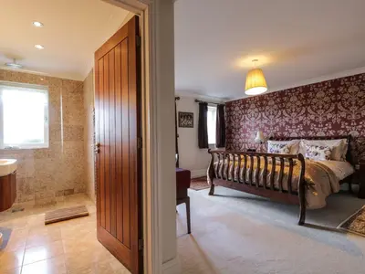 a bedroom with a bed and a walk in shower at Cloud End in Keswick