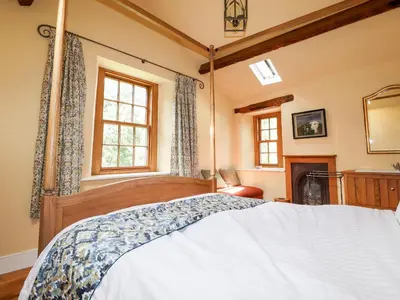 a bedroom with a large bed and a fireplace at Eagle Farmhouse in Glenridding