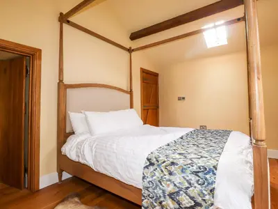 a bedroom with a four poster bed in it at Eagle Farmhouse in Glenridding
