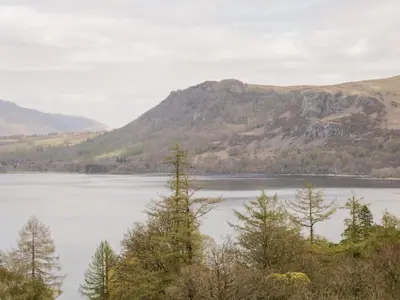 a view of a lake with trees in the foreground at Derwent Haven in Keswick