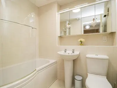 a bathroom with a sink and a toilet and a bath tub at Derwent Haven in Keswick