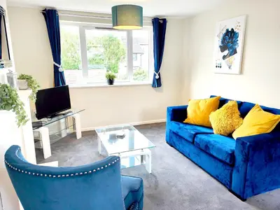 a living room with a blue couch and a table at Terrance House, modern, spacious in Carlisle