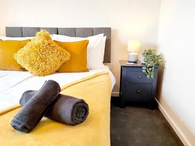 a bedroom with a bed with yellow pillows at Terrance House, modern, spacious in Carlisle